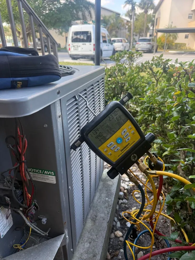Digital manifold gauge attached to a condenser reading refrigerant pressure