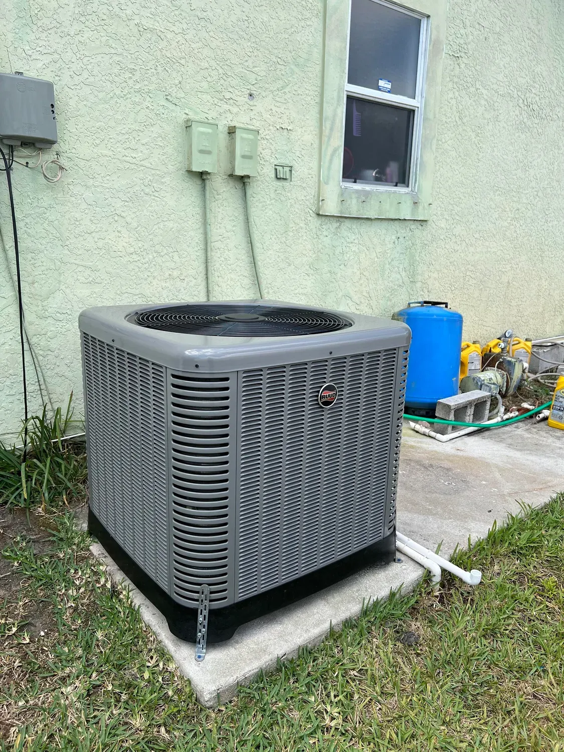 Newly installed Ruud condenser unit beside a residential home